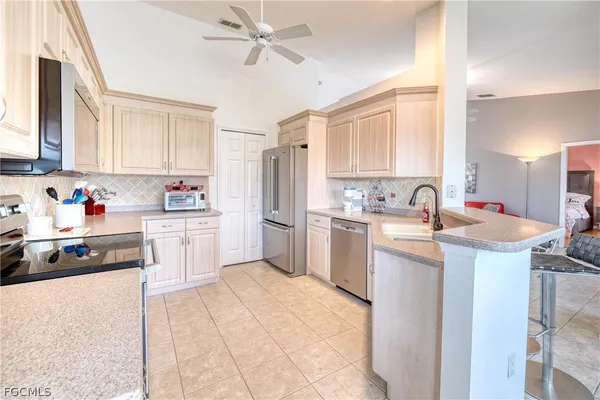 a kitchen with a sink window and white cabinets