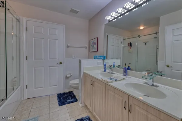 a spacious bathroom with a double vanity sink and mirror