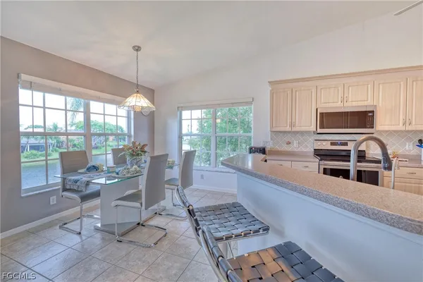 a kitchen with stainless steel appliances kitchen island granite countertop a sink and a stove