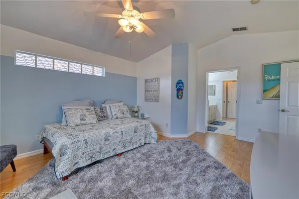 a spacious bedroom with a bed and a chandelier
