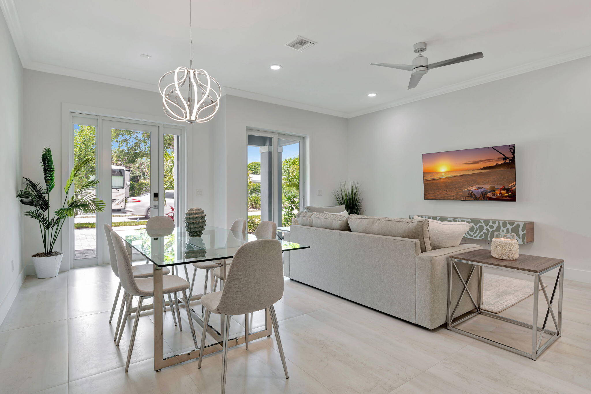 4680 Southeast Manatee Terrace Stuart, FL 34997 - Photo 5 of 34 a living room with furniture a chandelier and a flat screen tv