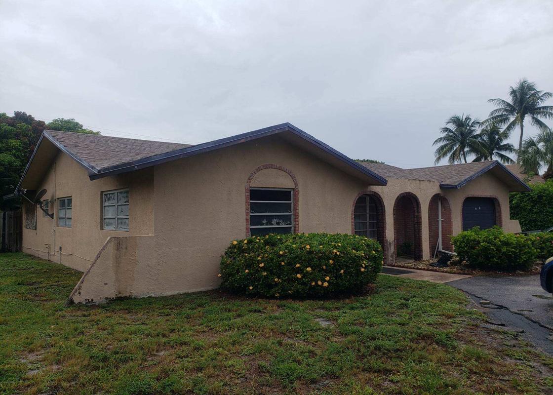 4663 Northeast 4th Avenue Boca Raton, FL 33431 - Photo 2 of 6 a house with green field in front of it