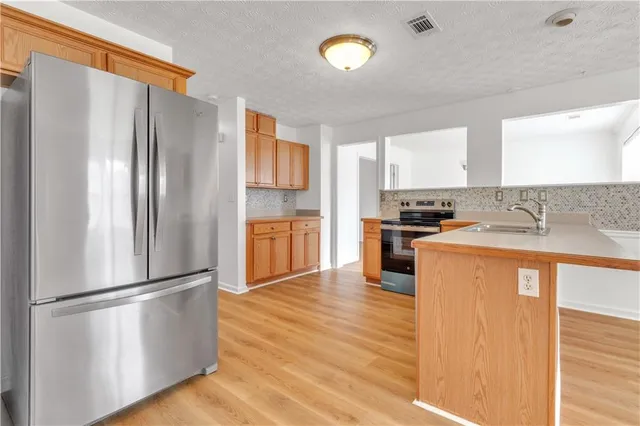 a kitchen with stainless steel appliances granite countertop a refrigerator sink and cabinets