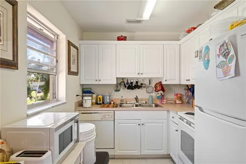 a kitchen with a sink a stove and cabinets