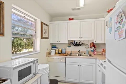 a kitchen with white cabinets and white appliances