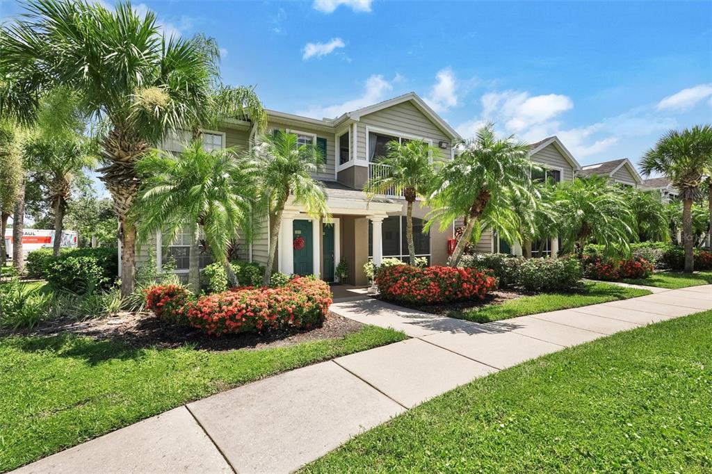 8932 Manor Loop, Unit 105 Lakewood Ranch, FL 34202 - Photo 1 of 1 a front view of a house with a garden and plants
