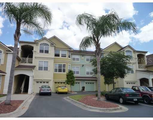 3373 South Kirkman Road, Unit 935 Orlando, FL 32811 - Photo 1 of 1 a front view of a house with a garden and tree