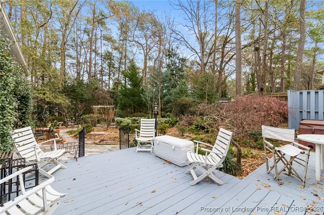 a view of a patio with table and chairs and couches with wooden floor and fence