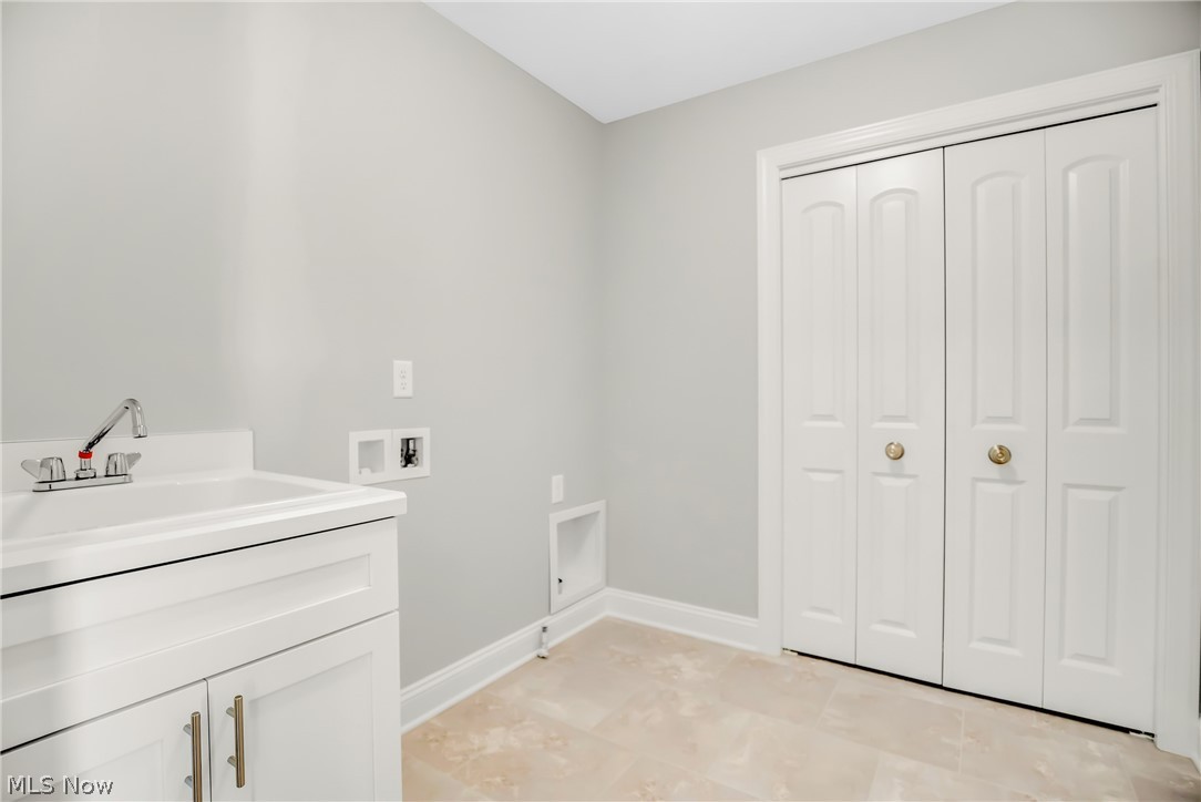12412 Snow Road Burton, OH 44021 - Photo 17 of 45 Washroom featuring sink, cabinets, hookup for a washing machine, and light tile floors