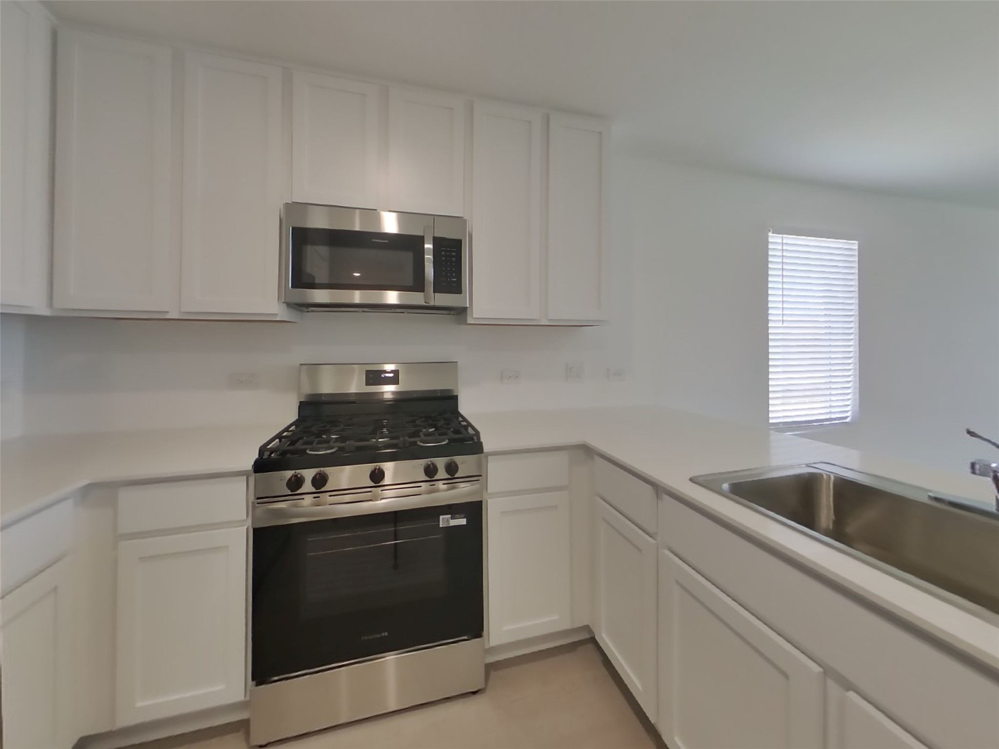 3009 Merganser Ridge Drive Katy, TX 77493 - Photo 4 of 18 a kitchen with white cabinets and stainless steel appliances