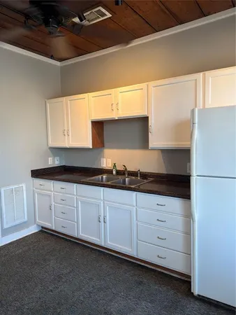 a kitchen with granite countertop white cabinets and white appliances