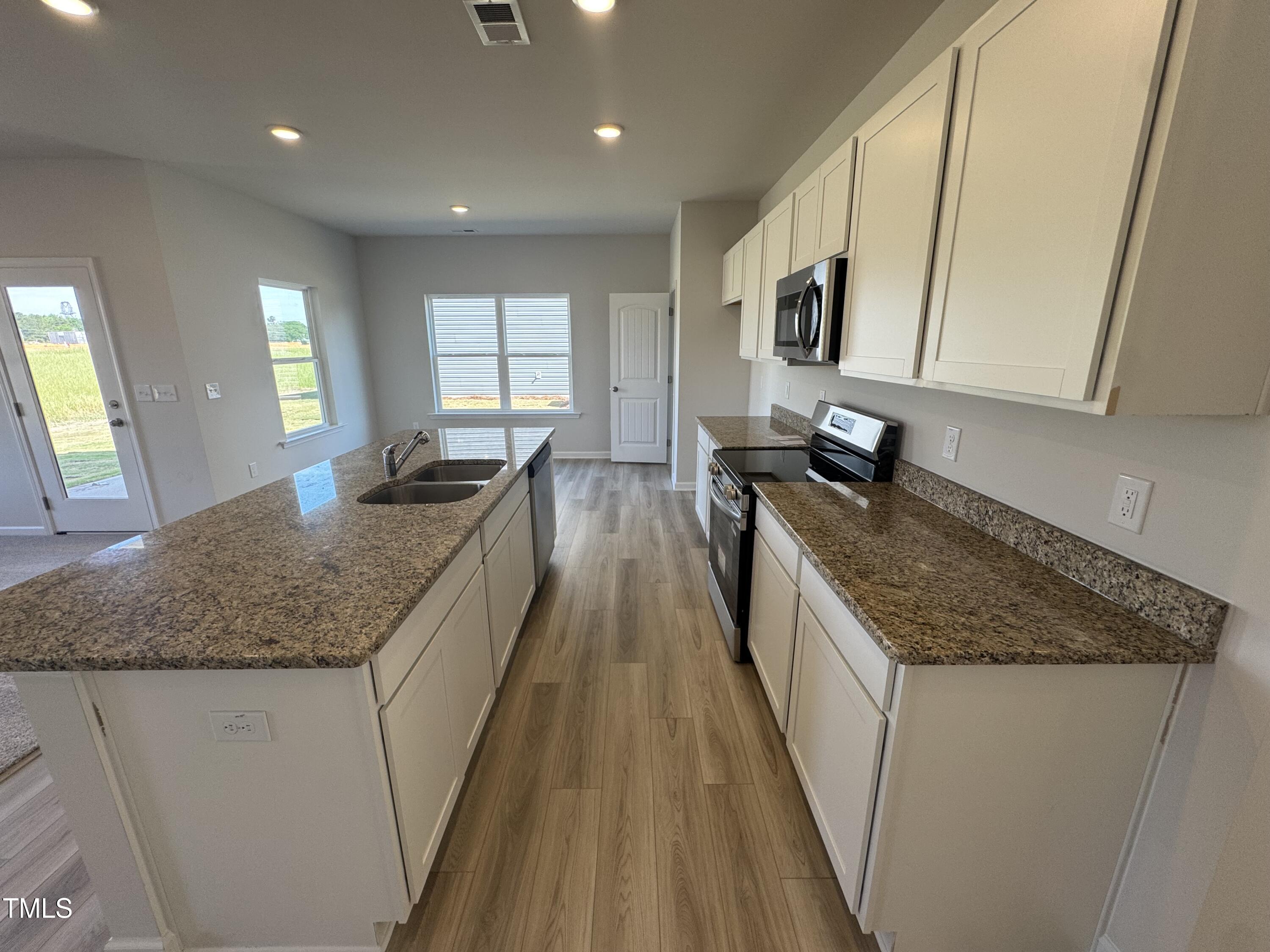 176 Bruce Drive Dunn, NC 28334 - Photo 8 of 30 a kitchen with counter top space a sink wooden floor and stainless steel appliances