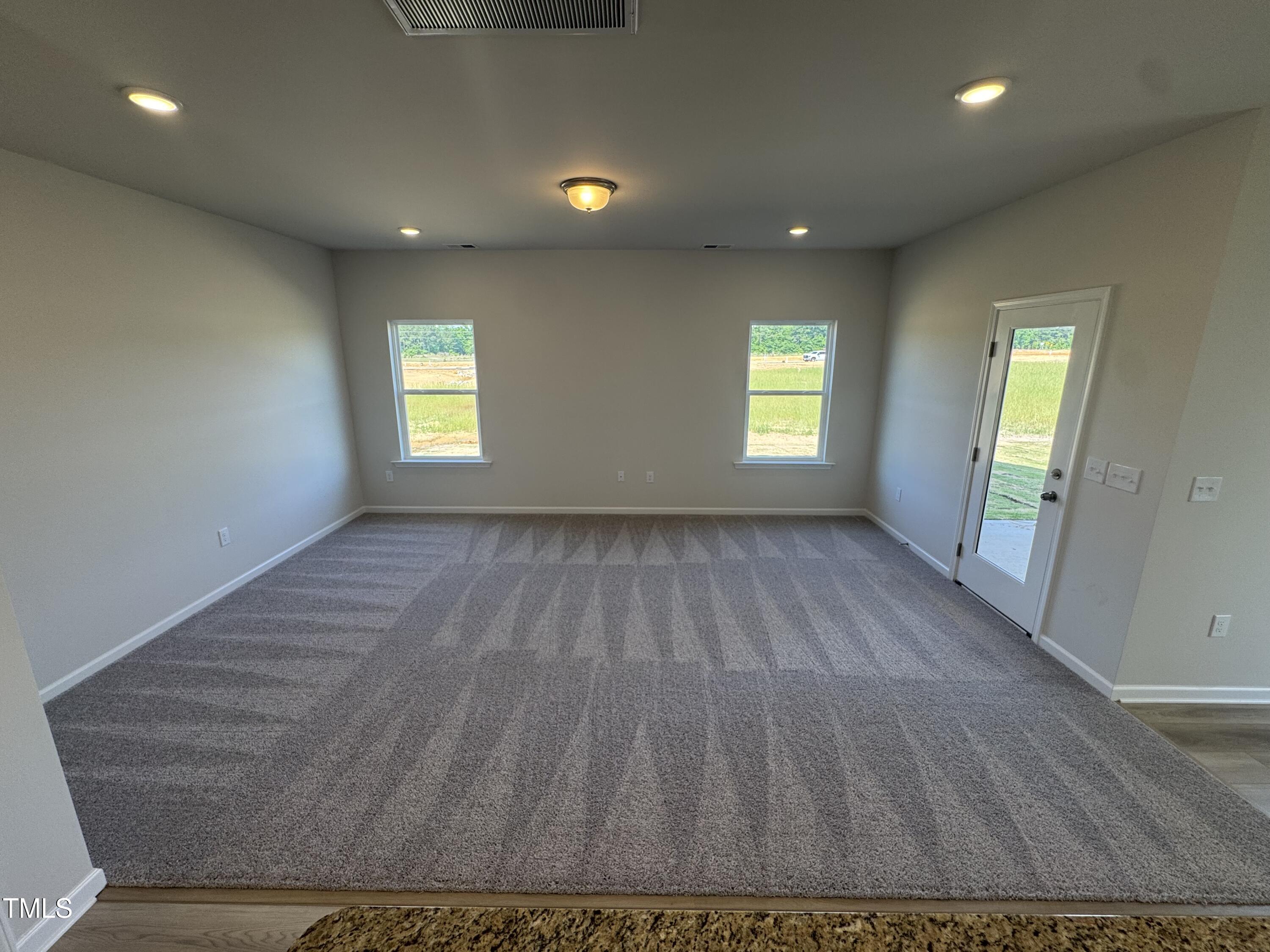 176 Bruce Drive Dunn, NC 28334 - Photo 9 of 30 an empty room with wooden floor and windows