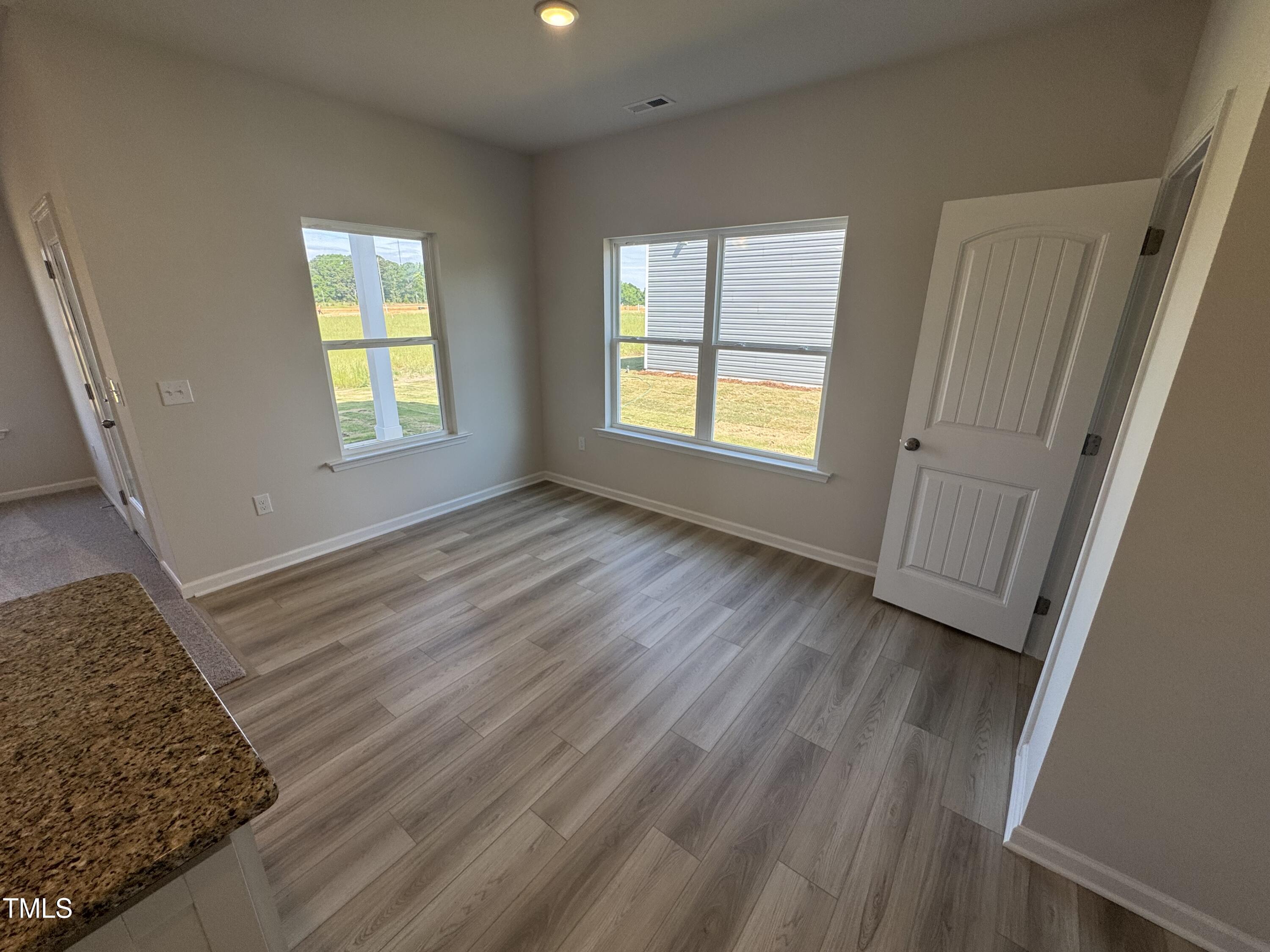 176 Bruce Drive Dunn, NC 28334 - Photo 10 of 30 a view of an empty room with wooden floor and a window