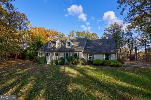 a view of a house with a big yard and large trees