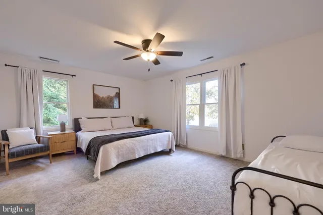 a spacious bedroom with a bed and a ceiling fan