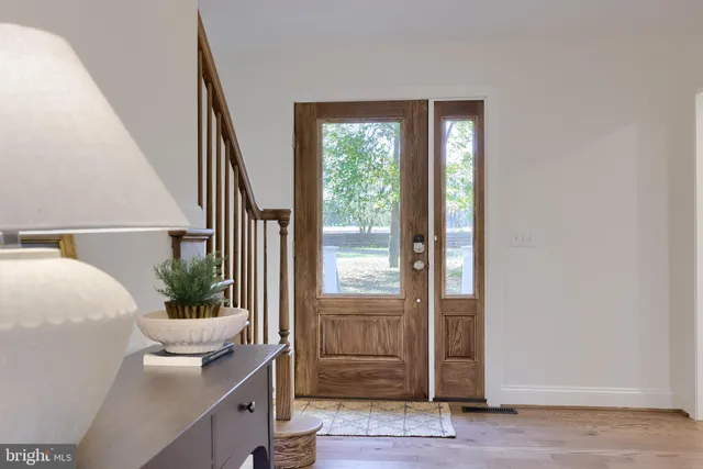a kitchen with stainless steel appliances granite countertop a stove a sink and white cabinets with wooden floor