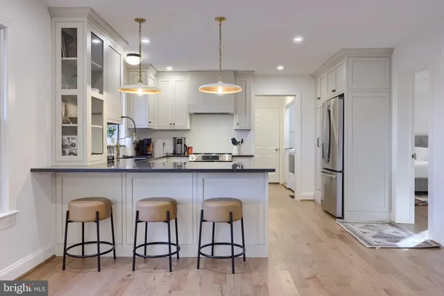 a open kitchen with white cabinets and stainless steel appliances