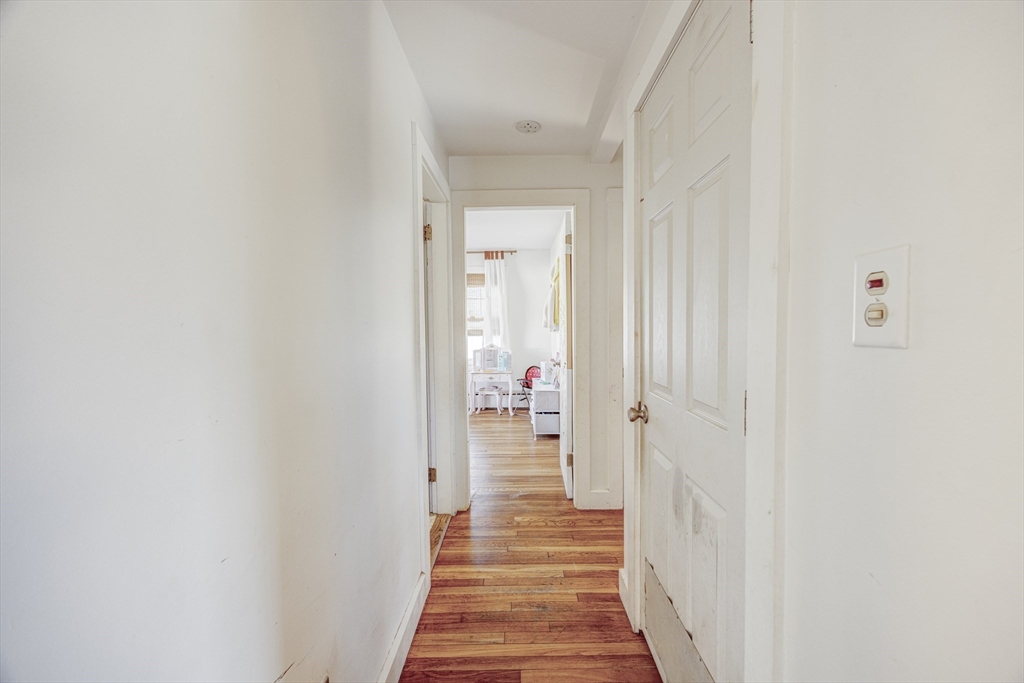 707 Hathaway Road New Bedford, MA 02740 - Photo 13 of 33 a view of a hallway with wooden floor and a bathroom