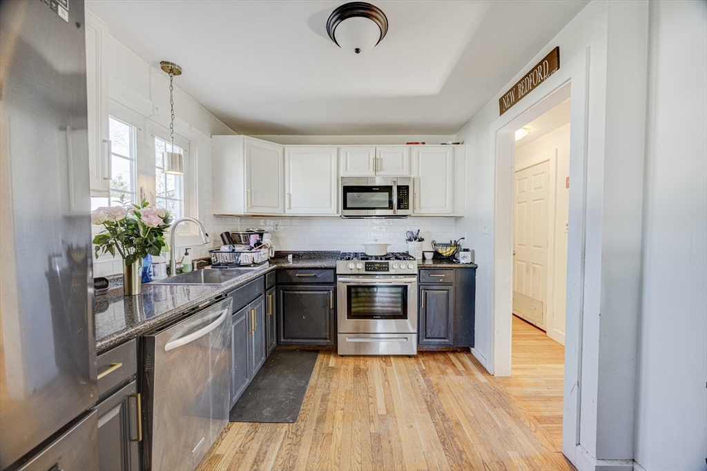 707 Hathaway Road New Bedford, MA 02740 - Photo 6 of 33 a kitchen with stainless steel appliances granite countertop a stove a sink and a refrigerator