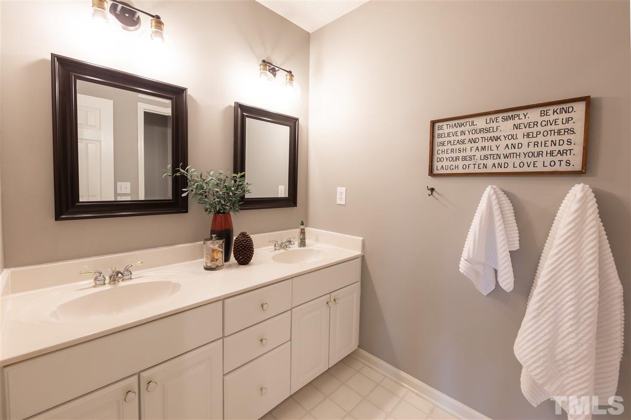 8901 Breeland Way Raleigh, NC 27613 - Photo 16 of 24 a bathroom with a double vanity sink and a mirror