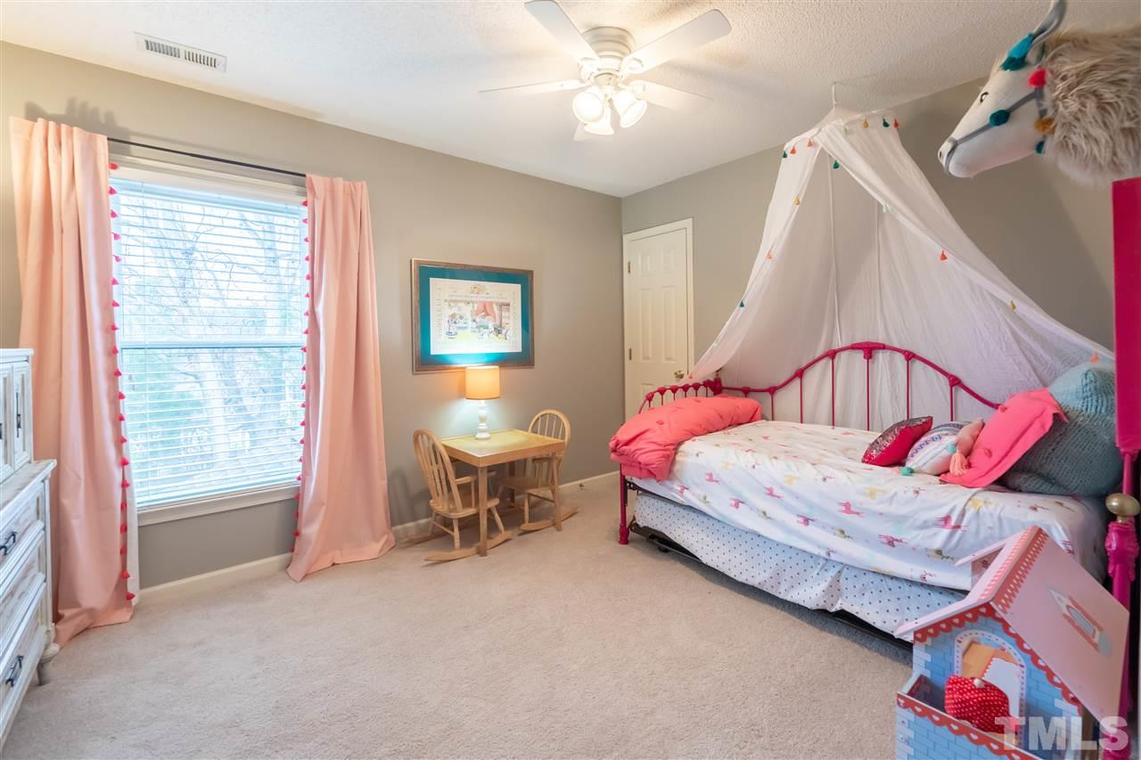 8901 Breeland Way Raleigh, NC 27613 - Photo 17 of 24 a bedroom with a bed and a chandelier