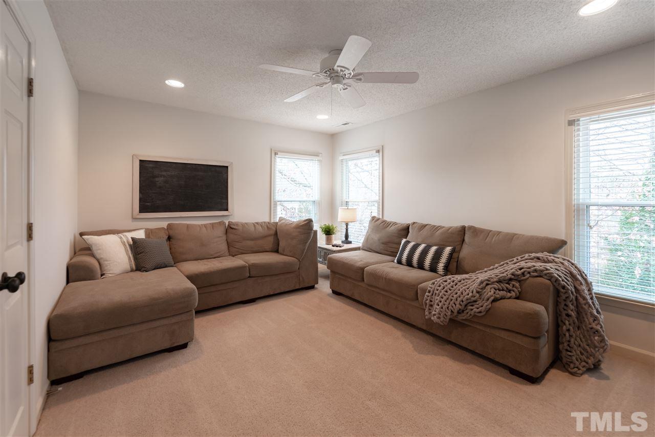 8901 Breeland Way Raleigh, NC 27613 - Photo 19 of 24 a living room with a couch and a flat screen tv