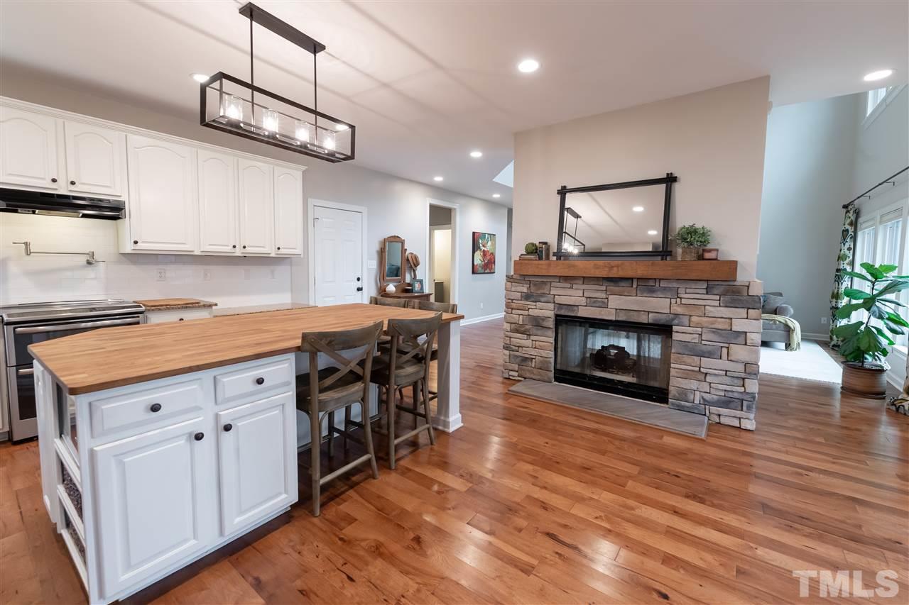 8901 Breeland Way Raleigh, NC 27613 - Photo 4 of 24 a kitchen with stainless steel appliances granite countertop a stove top oven a sink and cabinets
