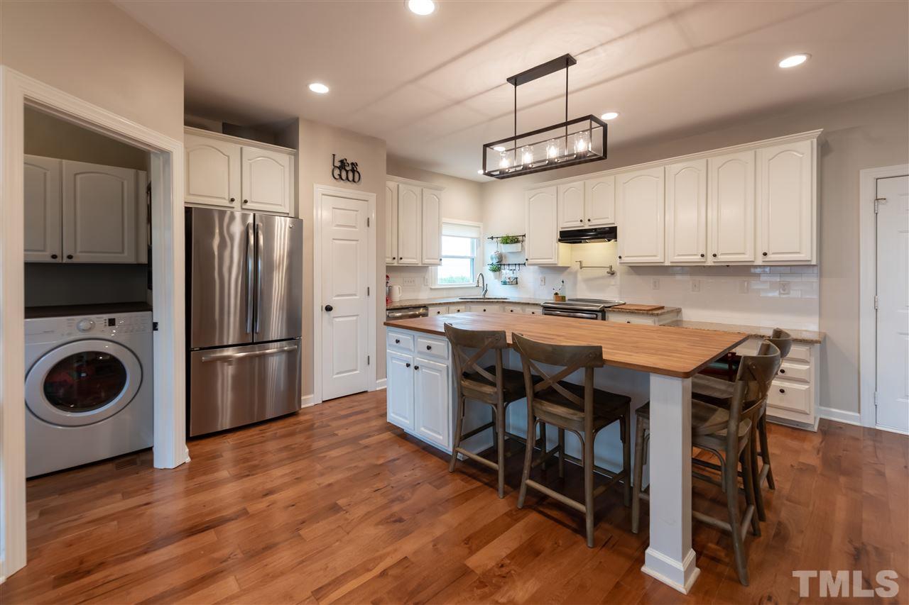 8901 Breeland Way Raleigh, NC 27613 - Photo 6 of 24 a kitchen with a table chairs refrigerator and microwave