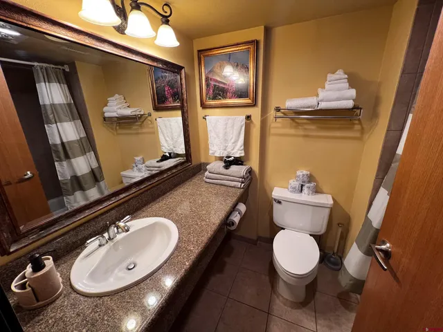a bathroom with a sink mirror vanity and toilet