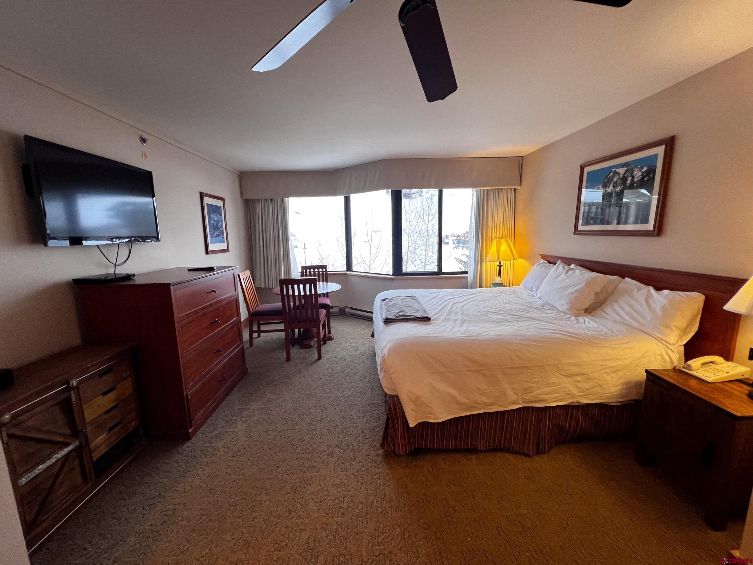 6 Emmons Road, Unit 521 Crested Butte, CO 81225 - Photo 2 of 19 a spacious bedroom with a bed and a flat screen television