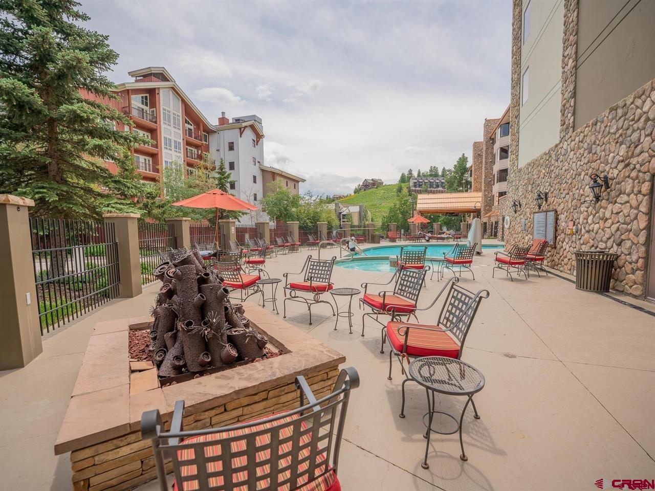 6 Emmons Road, Unit 521 Crested Butte, CO 81225 - Photo 8 of 19 a view of a chairs and tables in the patio with a barbeque grill and a yard