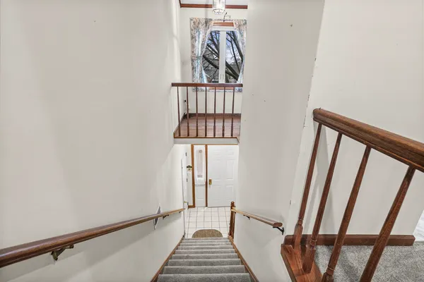 a view of a hallway with wooden floor and stairs