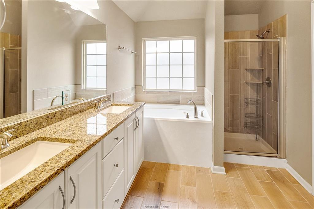 2027 Stubbs Drive Bryan, TX 77807 - Photo 12 of 23 Full bath with double vanity, a sink, a bath, and