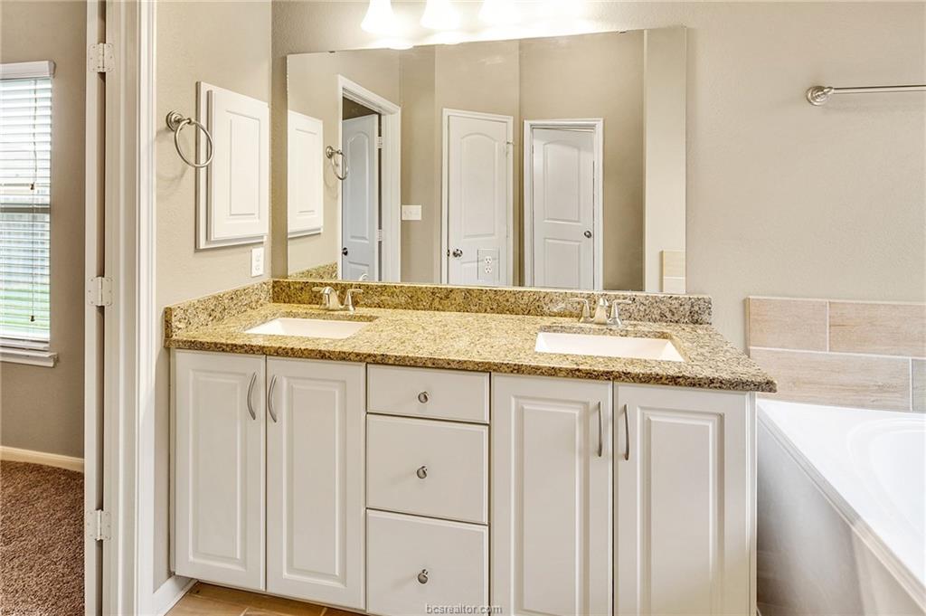 2027 Stubbs Drive Bryan, TX 77807 - Photo 14 of 23 Full bath with double vanity, a bath, and a sink
