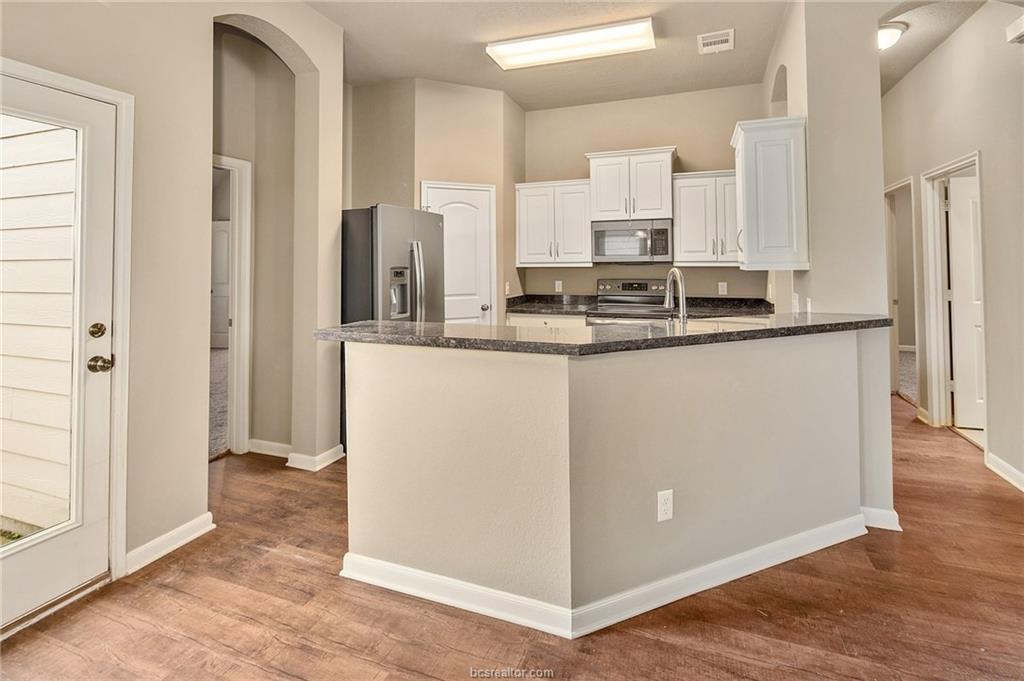 2027 Stubbs Drive Bryan, TX 77807 - Photo 7 of 23 Kitchen with light wood finished floors, white cab