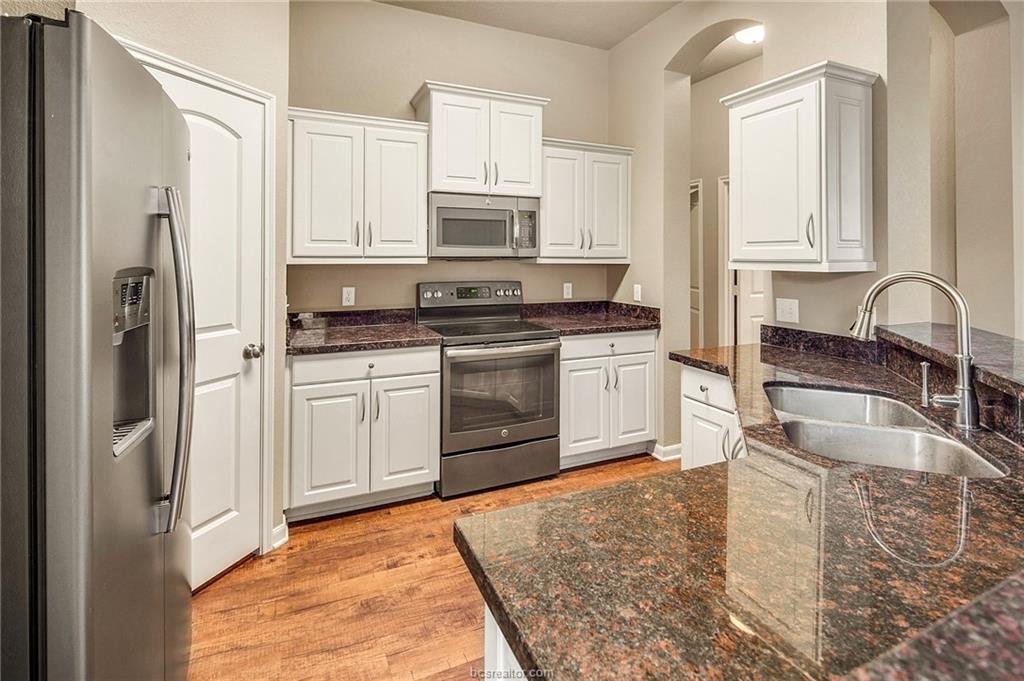 2027 Stubbs Drive Bryan, TX 77807 - Photo 8 of 23 Kitchen featuring white cabinetry, light wood fini