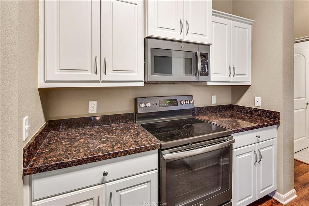 2027 Stubbs Drive Bryan, TX 77807 - Photo 9 of 23 Kitchen featuring white cabinetry, dark stone coun