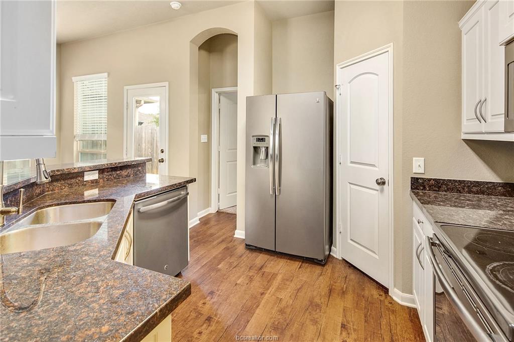 2027 Stubbs Drive Bryan, TX 77807 - Photo 10 of 23 Kitchen featuring a sink, white cabinetry, light w