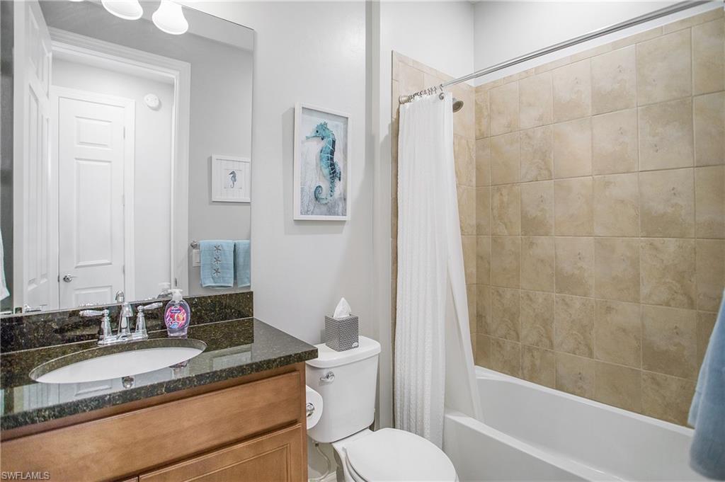 7674 Jacaranda Lane Naples, FL 34114 - Photo 15 of 45 a bathroom with a granite countertop sink toilet and shower
