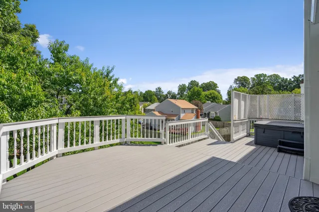 a view of a roof deck with wooden floor and fence with a bench