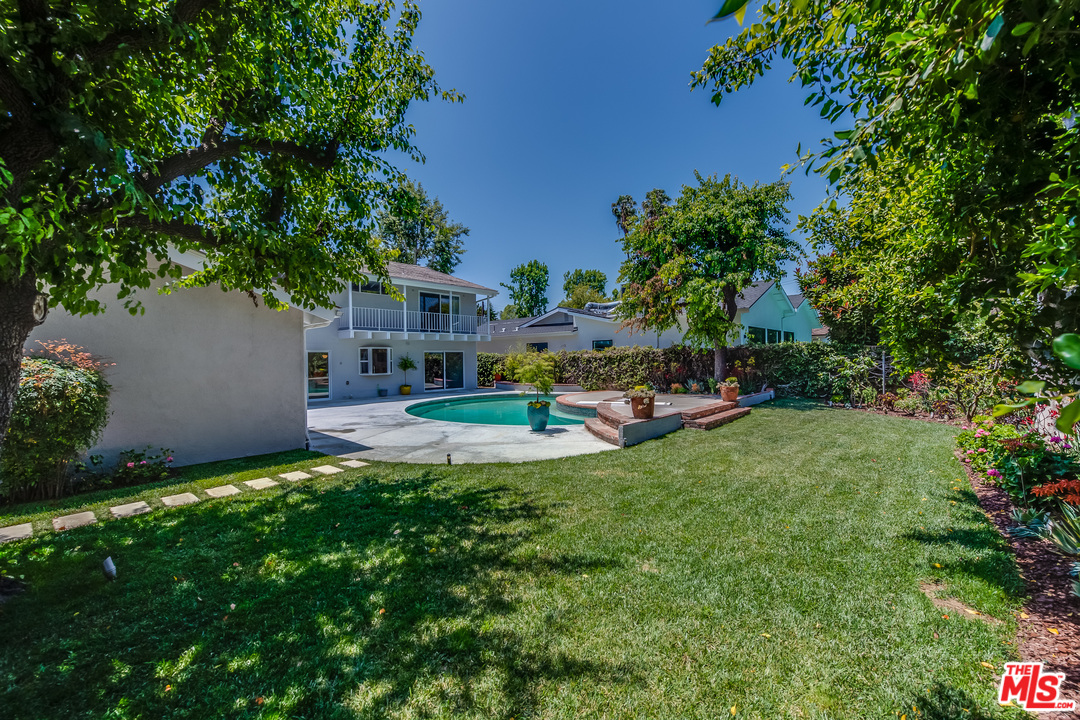 13133 Morrison Street Sherman Oaks, CA 91423 - Photo 26 of 26 a view of a garden with a bench in front of the house