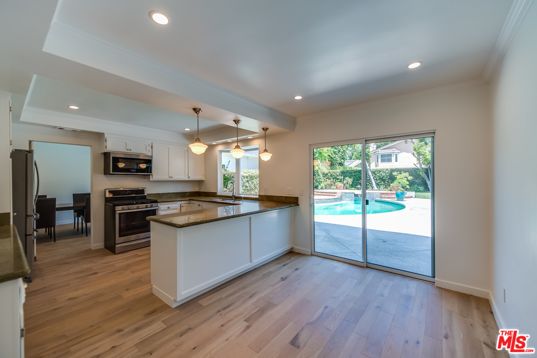 13133 Morrison Street Sherman Oaks, CA 91423 - Photo 6 of 26 a large kitchen with stainless steel appliances granite countertop a stove and a large window