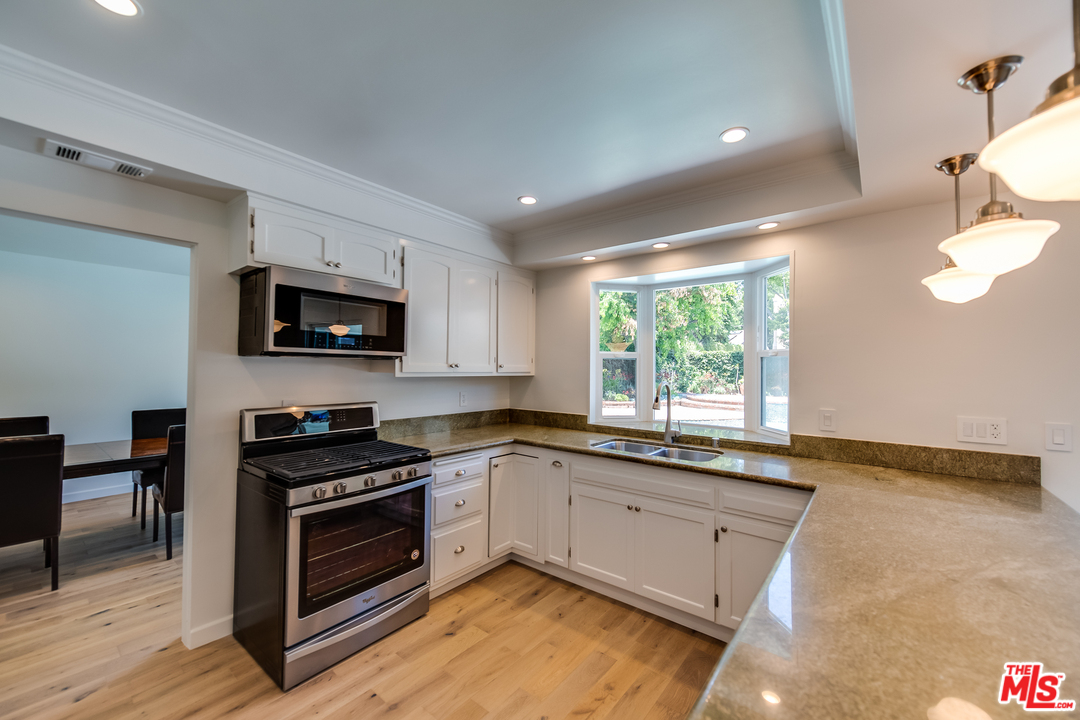 13133 Morrison Street Sherman Oaks, CA 91423 - Photo 7 of 26 a kitchen with stainless steel appliances granite countertop a stove a sink and a microwave