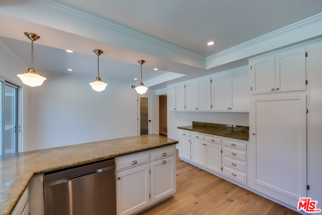 13133 Morrison Street Sherman Oaks, CA 91423 - Photo 8 of 26 a kitchen with granite countertop white cabinets and white appliances