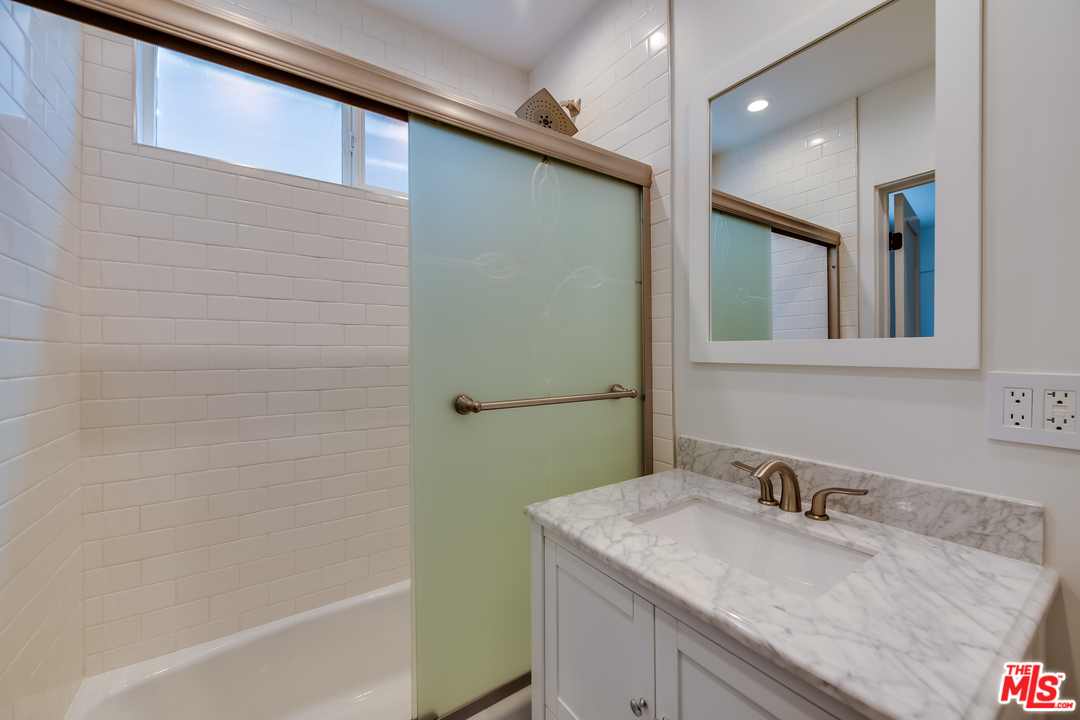 13133 Morrison Street Sherman Oaks, CA 91423 - Photo 10 of 26 a bathroom with a granite countertop sink and a mirror