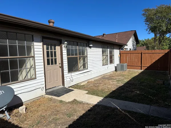 a backyard of a house with wooden floor and fence