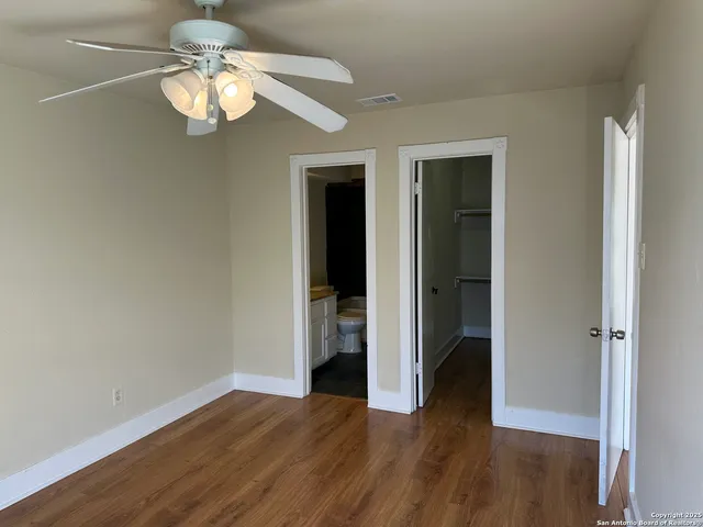 an empty room with wooden floor and chandelier