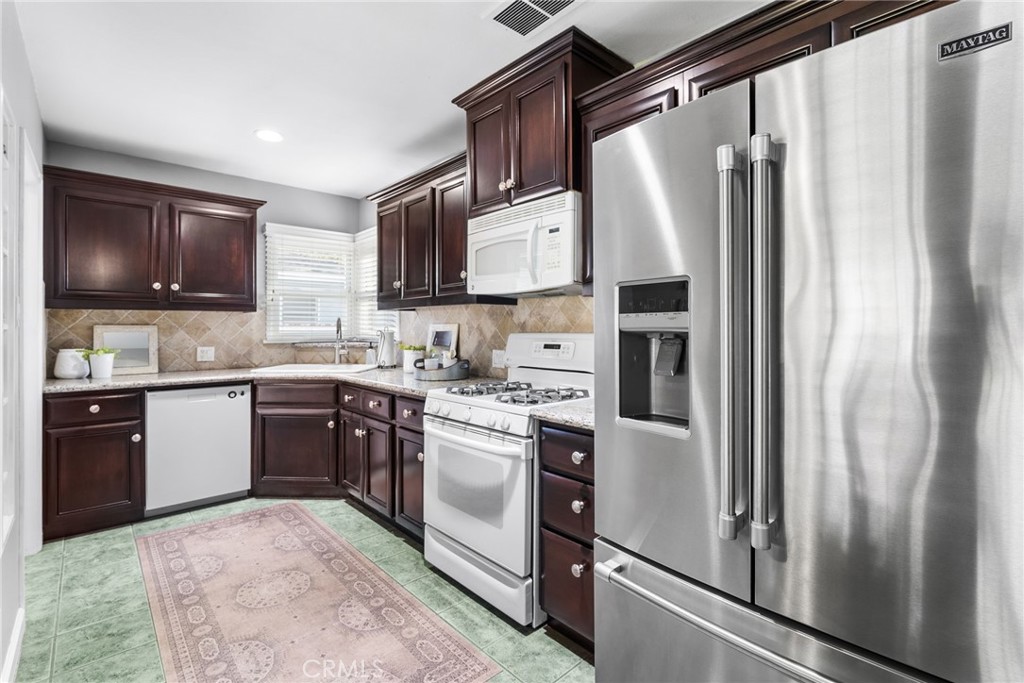 4651 Emerson Street Riverside, CA 92506 - Photo 8 of 30 a kitchen with stainless steel appliances granite countertop a refrigerator sink and microwave