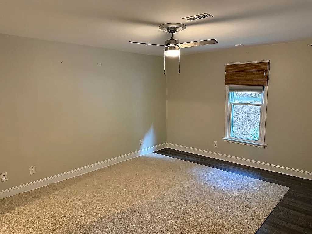 315 Rock Creek Road Clemson, SC 29631 - Photo 6 of 18 Plush carpeting meets rich wood-look flooring under a classic ceiling fan in this versatile space.
